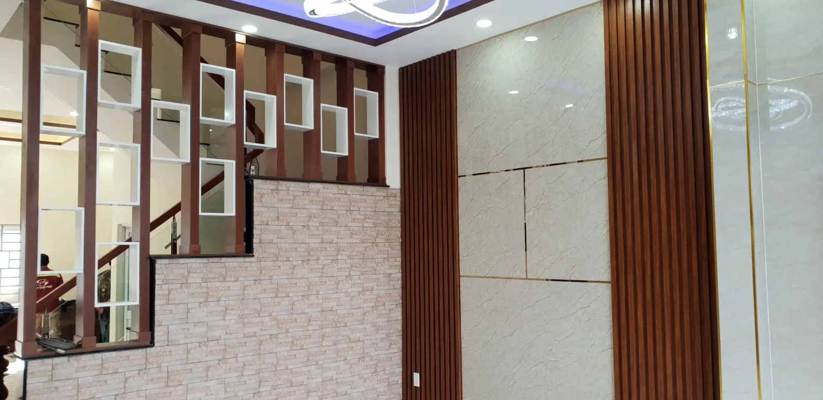 Lam gỗ cầu thang kết hợp kệ trang tr&iacute; ph&ograve;ng kh&aacute;ch nh&agrave; phố trọn g&oacute;i T&acirc;n Tạo B&igrave;nh T&acirc;n