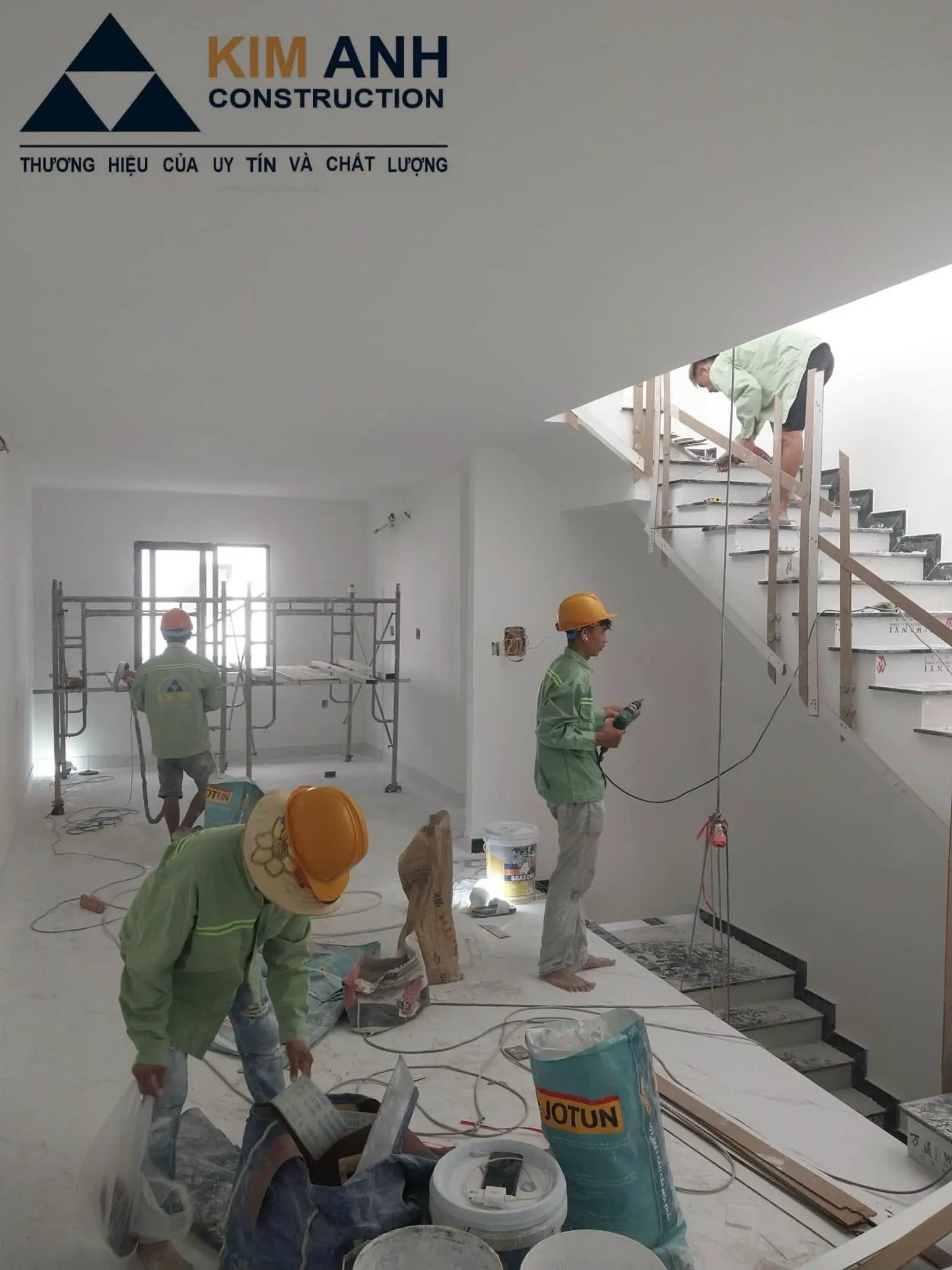 Nh&acirc;n c&ocirc;ng Kim Anh đang thi c&ocirc;ng phần bả sơn matit v&agrave; lan can cầu thang