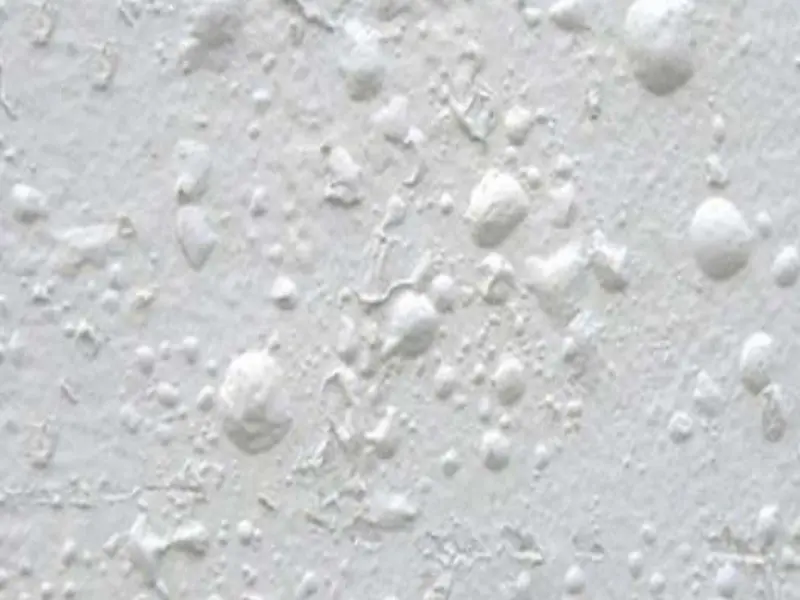 Cận cảnh một mảng tường mặt tiền bị phồng rộp, nứt nẻ lột ra từng mảng sơn do thầu thi công bả matit khi bề mặt vữa còn ướt sũng bên trong