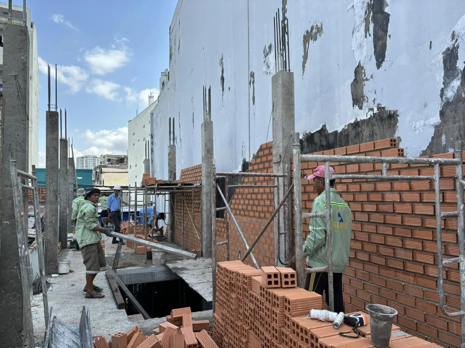 Kỹ sư Kim Anh đang kiểm tra độ thẳng đứng v&agrave; mạch vữa của một bức tường 20 ki&ecirc;n cố tại c&ocirc;ng trường thi c&ocirc;ng nh&agrave; phố